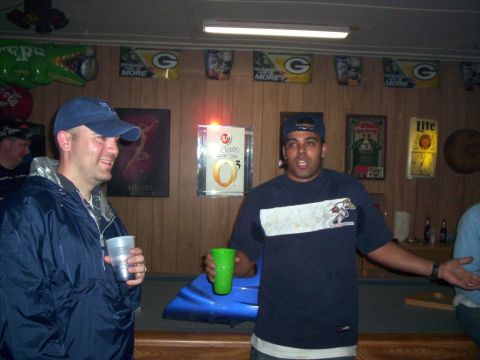 1986 Ford Bronco - Two men are holding drinks in a room that appears to be a bar or rec room, decorated with sports memorabilia.