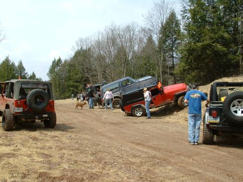 1991 Ford Bronco - A group of off-road vehicles are seen on a dirt trail, with some vehicles parked and others navigating the terrain.