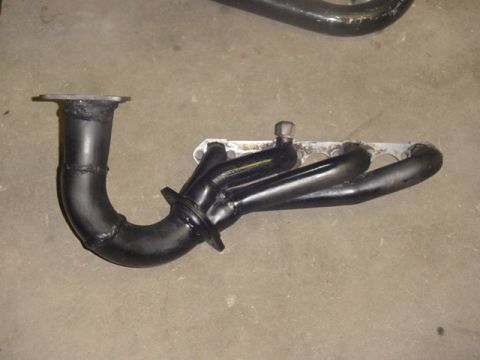 1995 Ford Mustang - Exhaust manifold part shown on a concrete floor.