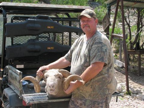 1986 Ford Bronco - A hunter proudly displays his ram next to a utility vehicle carrying hunting gear.