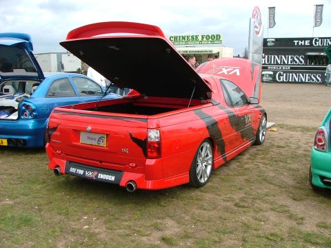 2001 Ford Fiesta - A red utility vehicle with black racing stripes is parked on grass with its tailgate and hood open.
