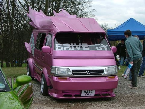 2001 Ford Fiesta - Custom pink van with unique fin modifications and 'DRIVE BY' windshield banner.