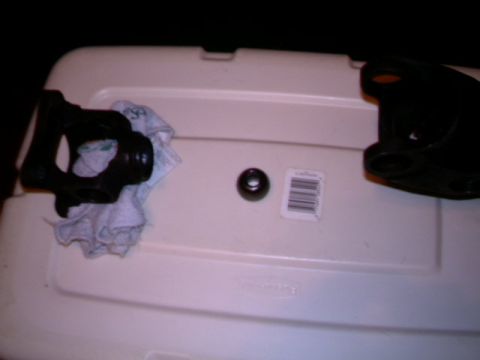 1987 Ford Bronco II - Parts laid out on a plastic container, including a driveshaft component and a small ring.