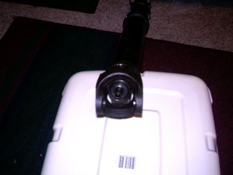 1987 Ford Bronco II - A driveshaft is shown resting on a white plastic container, with a barcode visible on the container.