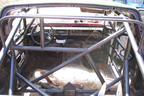 1978 Ford Bronco - The interior of a 1978 Ford Bronco is visible, heavily modified with a custom rollcage.