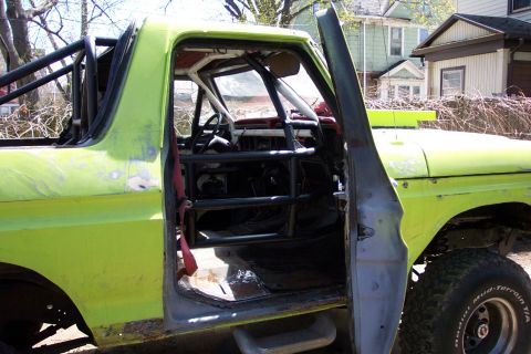 1978 Ford Bronco - Interior view of a 1978 Ford Bronco, modified with a full rollcage and safety harness.