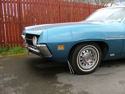 1970 Ford Ranchero - Front view of a blue 1970 Ford Ranchero 500 showing the fender, wheel, and grille detail.