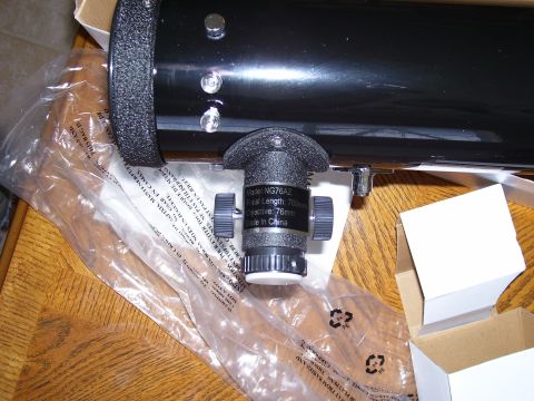1992 Ford Bronco - A close-up view of a telescope's focusing mechanism and barrel, resting on a wooden surface.