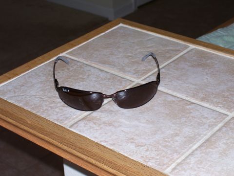 1992 Ford Bronco - A pair of brown sunglasses sits on a tiled surface.