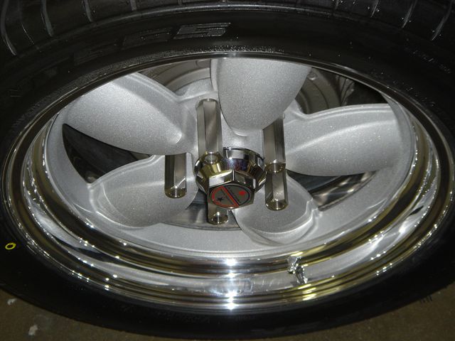 Close-up of a silver five-spoke wheel with a chrome lip and center cap