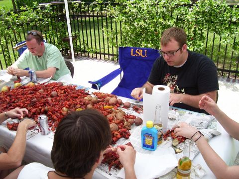1992 Ford Bronco - A group enjoys a crawfish boil outdoors, with a large pile of crawfish and potatoes on the table.