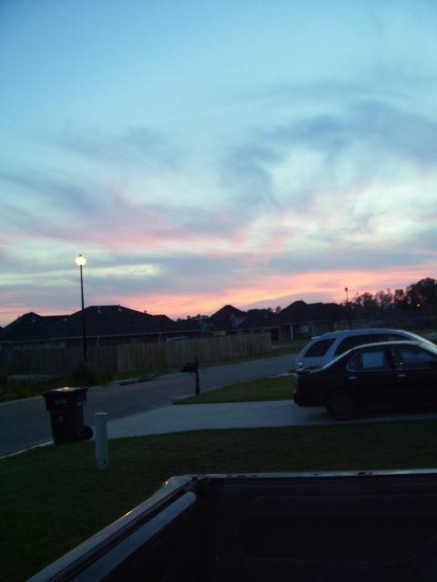 1992 Ford Bronco - A suburban street scene unfolds under a sky painted with the soft hues of dusk, with two vehicles parked in front of houses.
