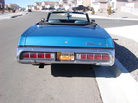 1973 Mercury Cougar - The rear of a blue convertible shows its taillights, chrome bumper, and a 'Cougar XR7' emblem.