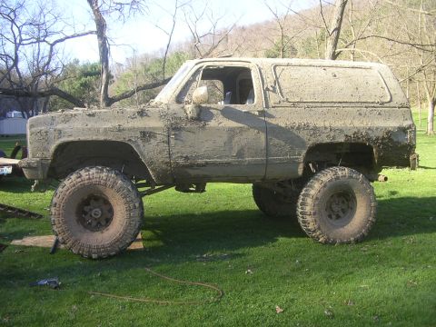 1989 GMC Jimmy - This heavily modified SUV is covered in mud, suggesting off-road use.