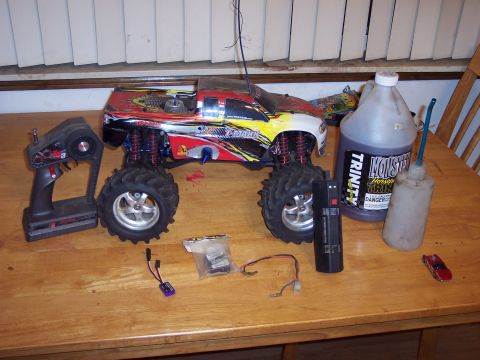 1974 Ford Bronco - A remote-controlled monster truck and its accessories are laid out on a table.