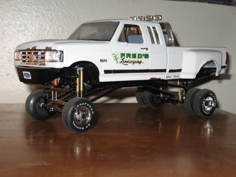 1977 Ford F-150 - Model truck with lifted suspension and custom decals sits on a wooden surface.