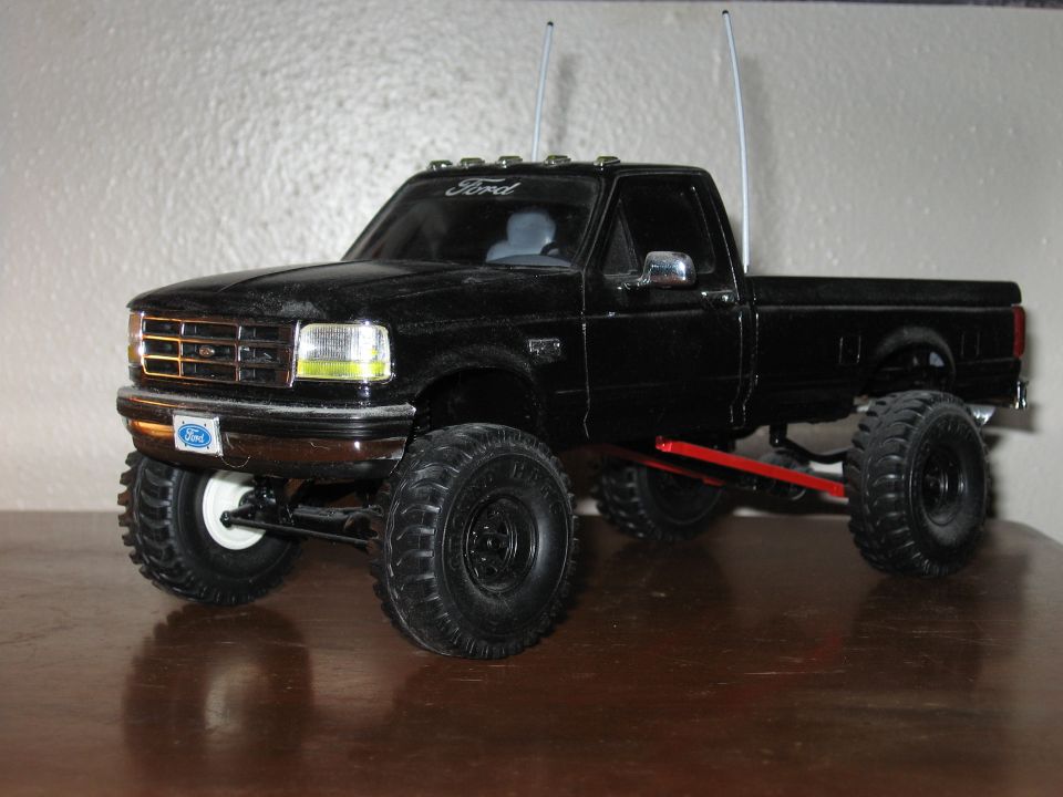 Black Ford F-series scale model truck with lift kit and roll bar on table