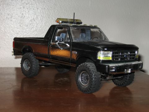 1977 Ford F-150 - Model truck with off-road tires and roof-mounted light bar.