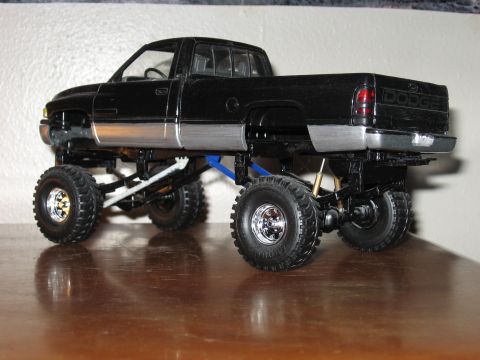 1977 Ford F-150 - Model truck with custom suspension and large tires sits on a wooden surface.