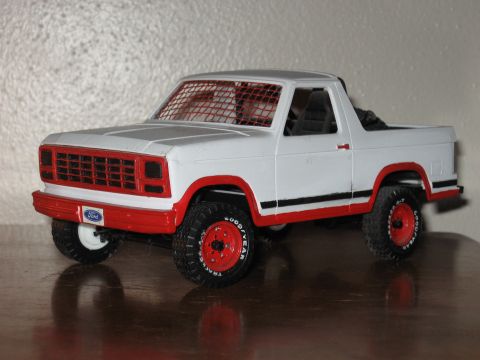 1977 Ford F-150 - This toy truck features a red grille, red wheels, and a black stripe along the side. The Ford logo is visible on the front.