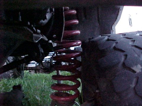 1982 Ford Bronco - Close-up view of a vehicle's suspension coil and tire.