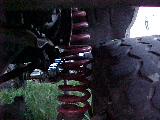 Close-up of red coil spring and tire tread