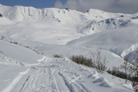 2003 Jeep TJ - A vast, snow-covered mountain range with numerous ski tracks visible on the slopes.