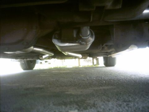 1985 Ford Crown Victoria LTD - The underside of a vehicle shows a newly installed exhaust system with dual tailpipes.