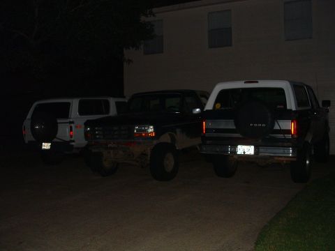 1993 Ford Bronco - A Ford Bronco is parked next to other vehicles at night.