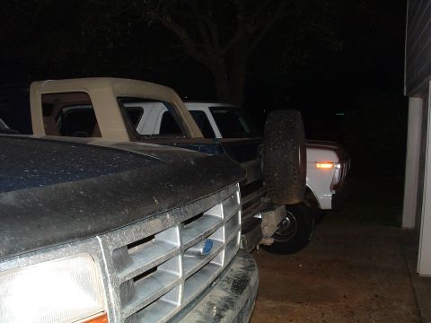 1993 Ford Bronco - Two Ford trucks, one appearing to be a 1993 Bronco, are parked next to each other in a driveway.