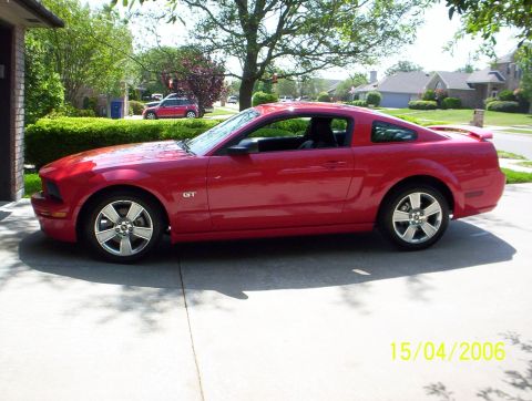 2006 Ford Mustang - Side view of a red 2006 Ford Mustang GT coupe with a spoiler.
