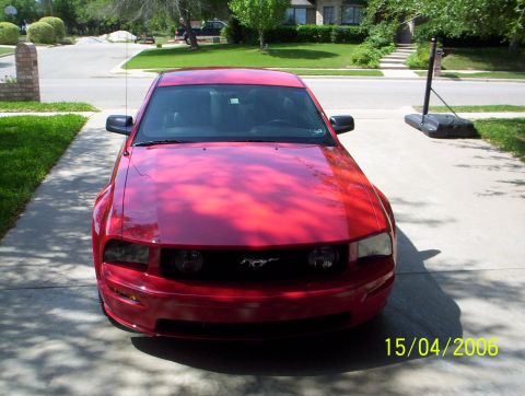 2006 Ford Mustang - A red Ford Mustang is parked in a driveway with a basketball hoop in the background.