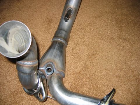 1995 Ford Bronco - Close-up view of a custom exhaust pipe, a sensor bung and a metal mounting bracket.