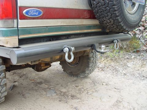 1996 Ford Bronco - The rear of a Ford Bronco features a spare tire mounted above a custom bumper with tow hitch and recovery points.