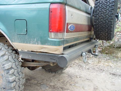 1996 Ford Bronco - Rear view of a green 1996 Ford Bronco, showing the spare tire, tow hitch, and distinctive taillight design.