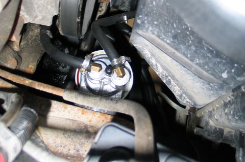 1994 Ford Bronco - Close-up view of a vehicle's fuel filter assembly with visible hoses and engine bay components.