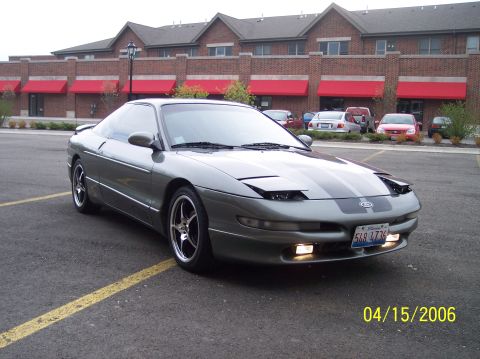 1995 Ford Probe - A gray 1995 Ford Probe with racing stripes is parked in a lot.