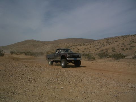 1985 Ford Ranger - A lifted 1985 Ford Ranger kicks up dust while driving on a dirt road through a desert landscape.