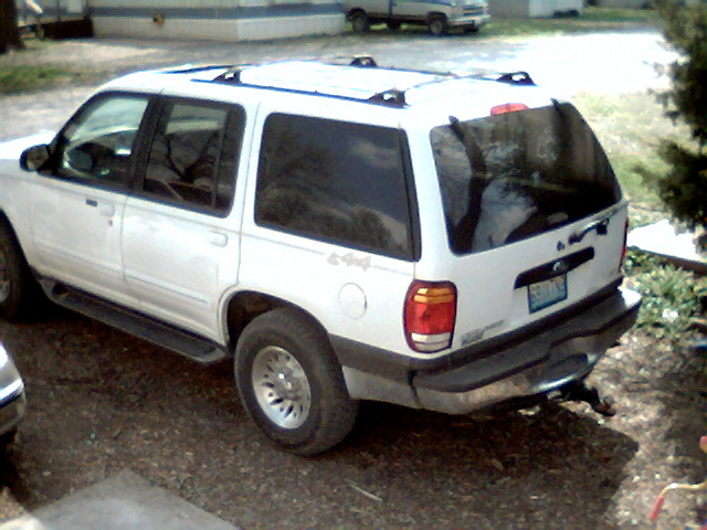 White 1999 Ford Explorer parked on gravel, rear-view