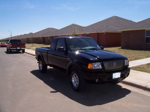 2003 Ford Ranger - A black 2003 Ford Ranger pickup truck is parked on a residential street under a clear blue sky.