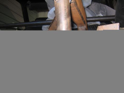 1969 Ford Mustang - Detail of an exhaust pipe and vehicle frame, with some markings visible on the pipe.