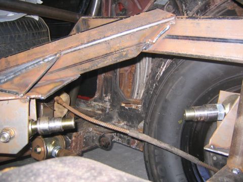 1969 Ford Mustang - Custom rear suspension fabrication with welded metal brackets and a tire visible.