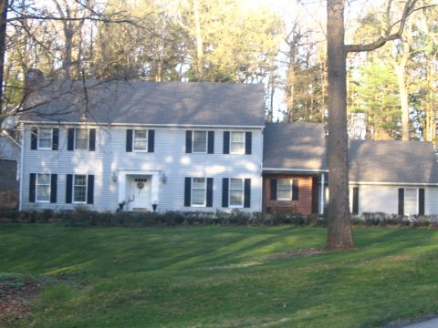 1989 Ford Bronco - A two-story house with a prominent tree in the foreground, set against a backdrop of bare trees.