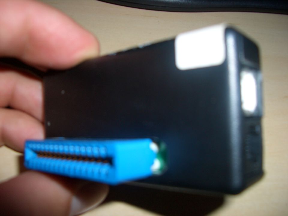 Black electronic device with a blue connector and a white sticker