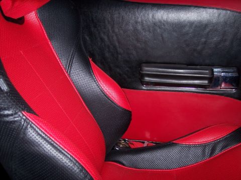 1972 Ford Ranchero - The interior features a two-tone red and black seat design with perforated sections and a matching door panel.