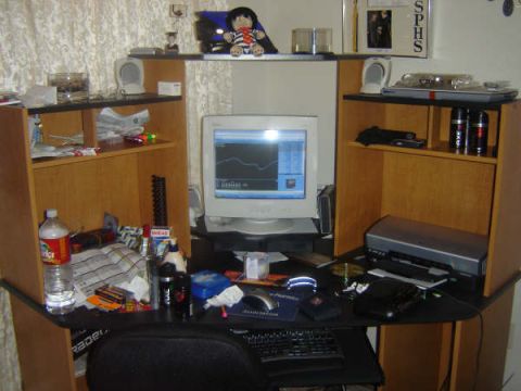 1988 Ford LTD Crown Victoria - A cluttered desk area features a computer monitor, printer, and shelves filled with various objects.