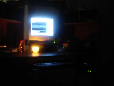 1988 Ford LTD Crown Victoria - A dimly lit room shows a computer monitor and desk setup with a glowing candle.