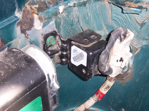 1996 Ford Bronco - Close-up of a Ford airbag sensor assembly, showing wiring and mounting bracket.