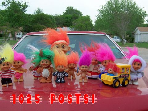 1979 Ford Ranchero - A variety of troll dolls are arranged on the hood of a red vehicle, with text overlaying the image.