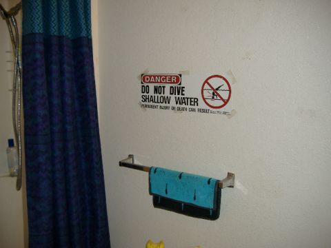 1979 Ford Bronco - A sign warns of the dangers of diving in shallow water, with a towel hanging nearby.